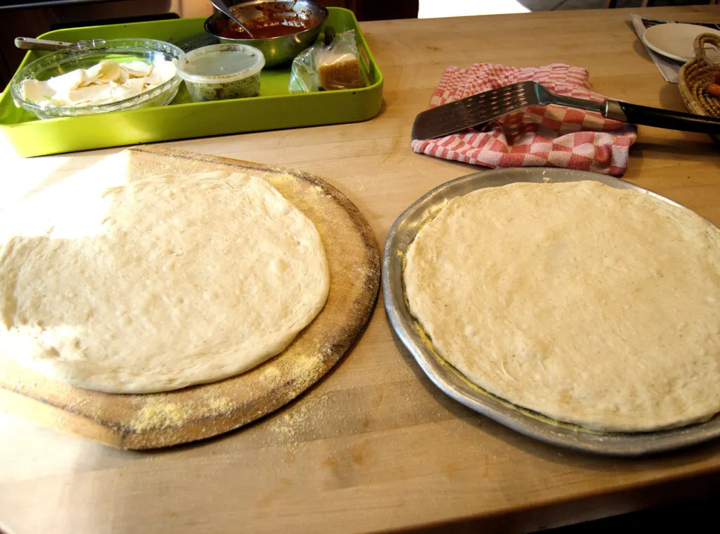 two pizzas ready for topping