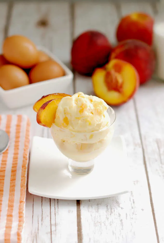 a dish of roasted peach ice cream with eggs and peaches in the background