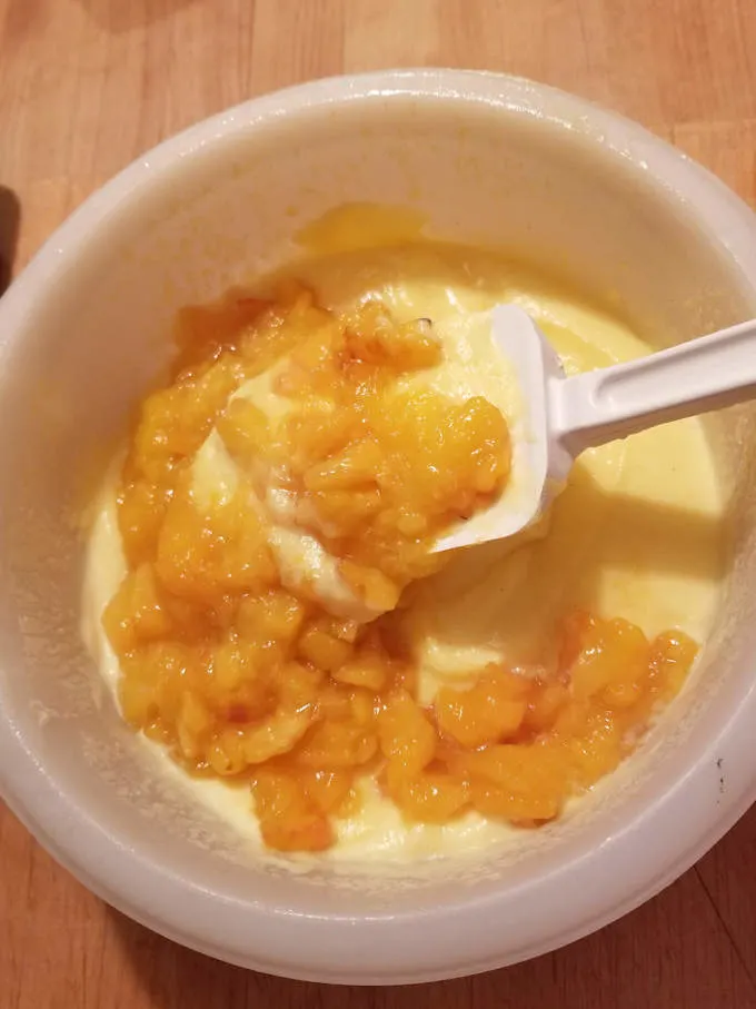 folding roasted peaches into ice cream custard base.