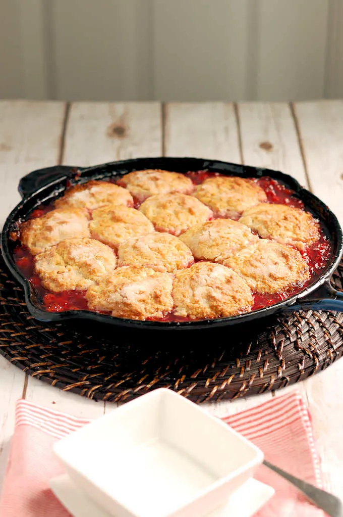 a cast iron skillet with sour cherry cobbler