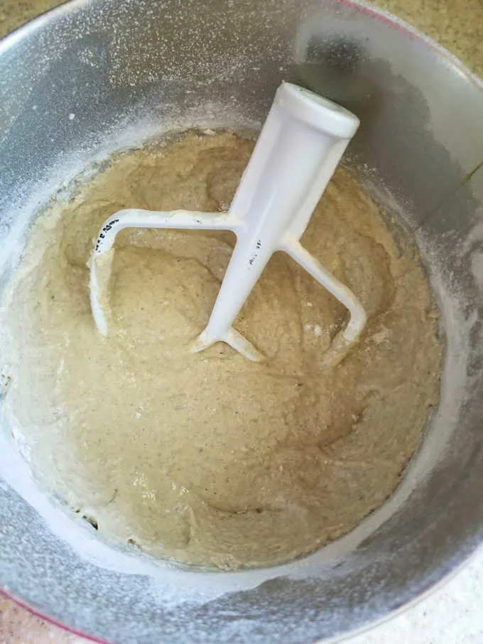 a bread starter in a mixer bowl with a mixing paddle.