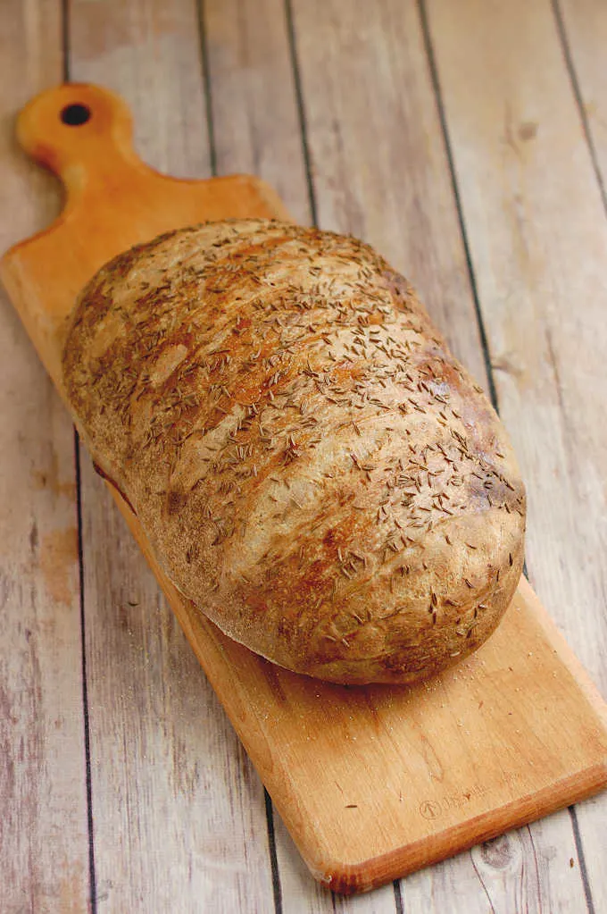 a loaf of sourdough rye bread on a cutting board