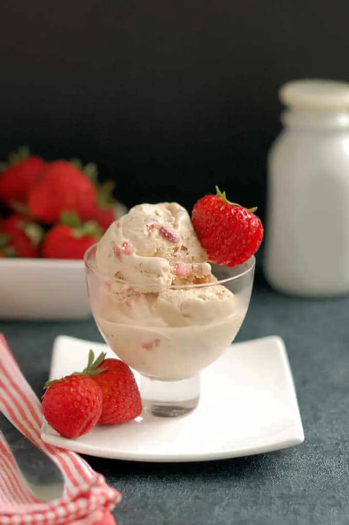 a bowl of homemade strawberry ice cream with fresh berries