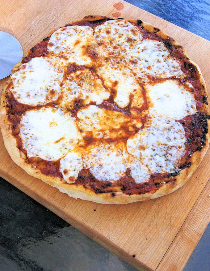 a freshly baked pizza on a cutting board