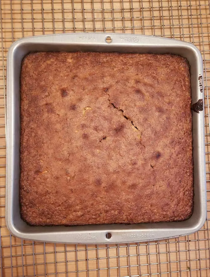 a freshly baked zucchini cake cooling on a rack.