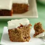 a partially eaten slice of zucchini cake on a plate with a fork