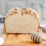 a sliced loaf of honey oatmeal bread on a cutting board
