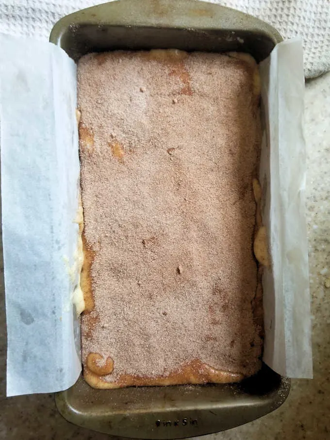 a loaf pan filled with snickerdoodle bread batter