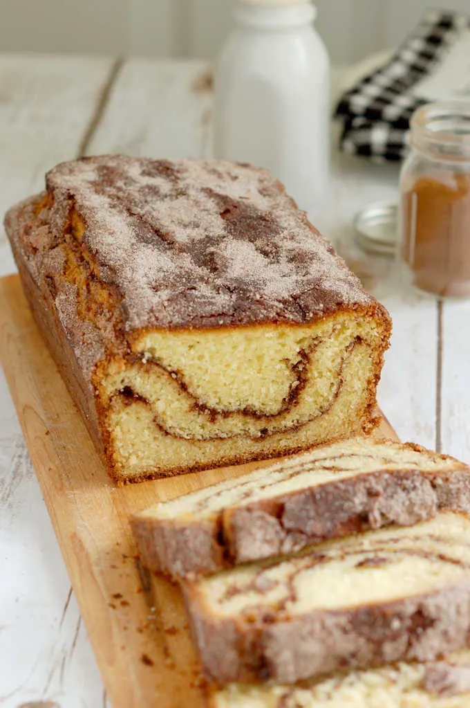 a sliced loaf of snickerdoodle bread on a cutting board