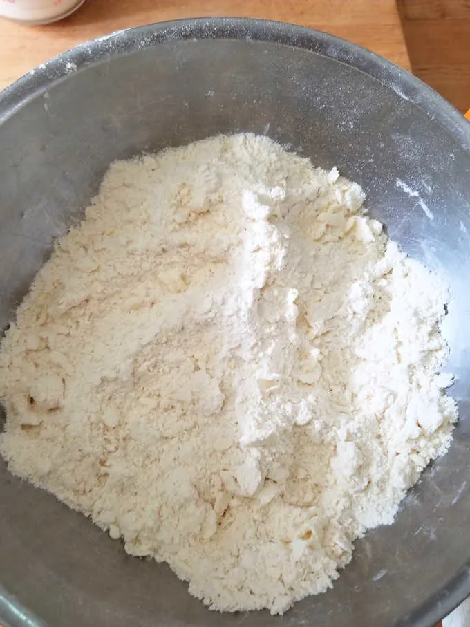 a bowl with flour and butter mix for biscuit dough