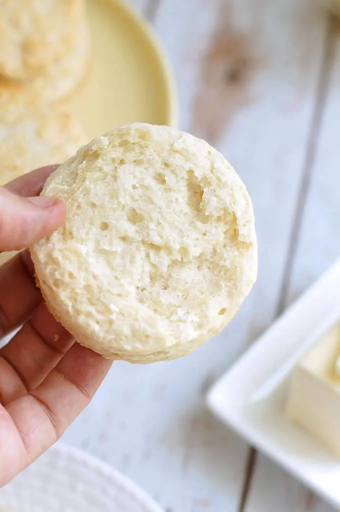 a hand holding half a sourdough biscuit