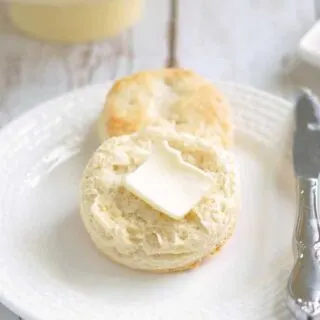 a sourdough biscuit on a plate with a pat of butter