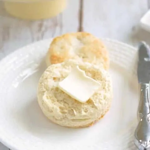 a sourdough biscuit on a plate with a pat of butter