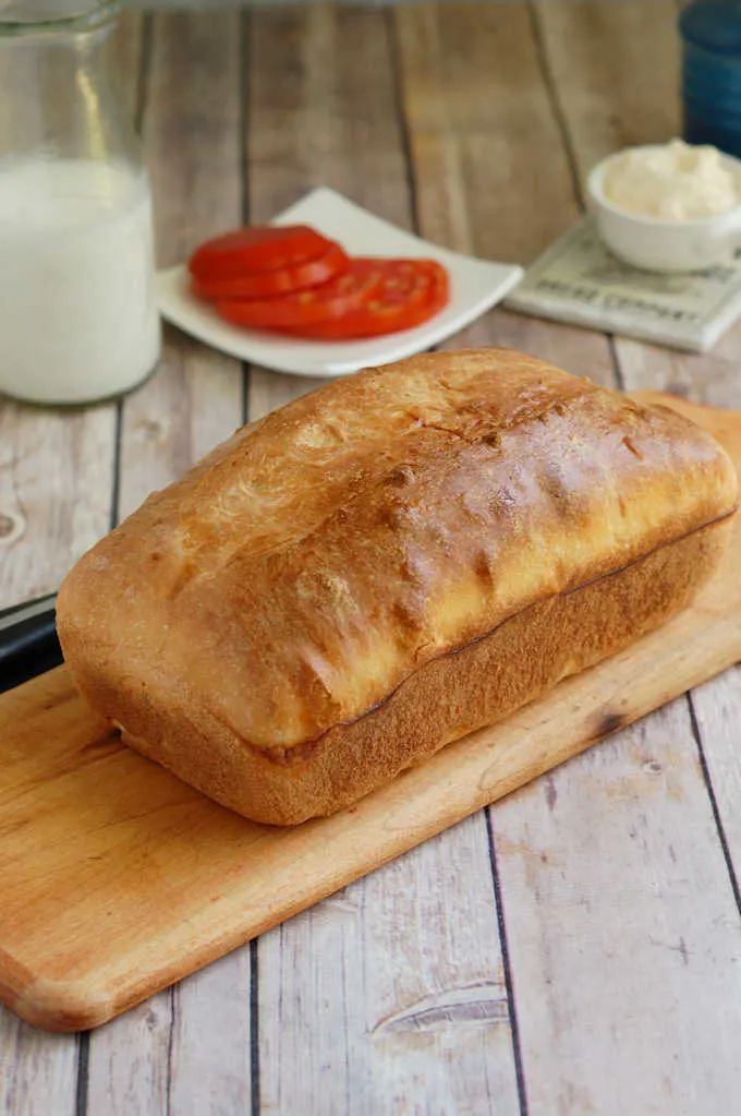a loaf of sourdough sandwich bread on a cutting board