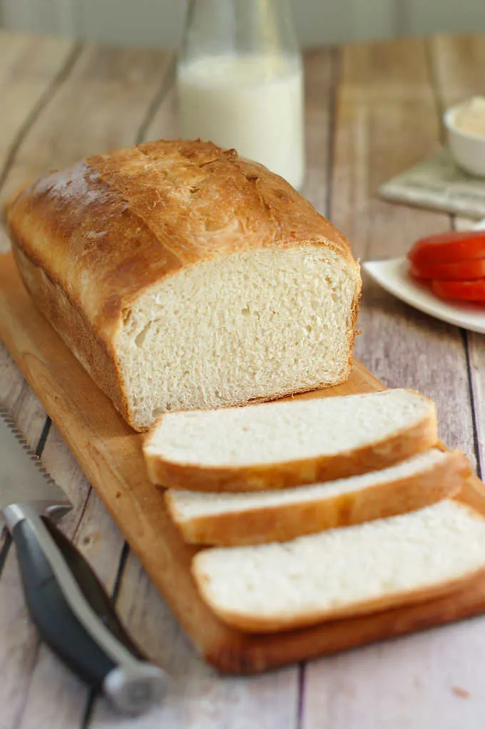 a sliced loaf of sourdough sandwich bread on a cutting board