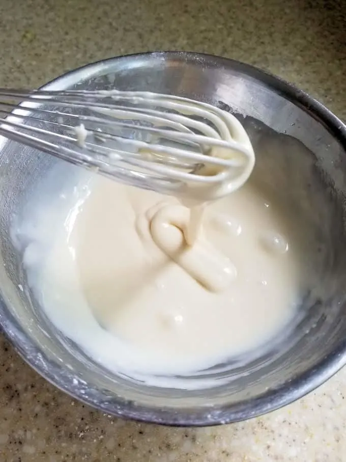 a bowl of apple glaze with a whisk