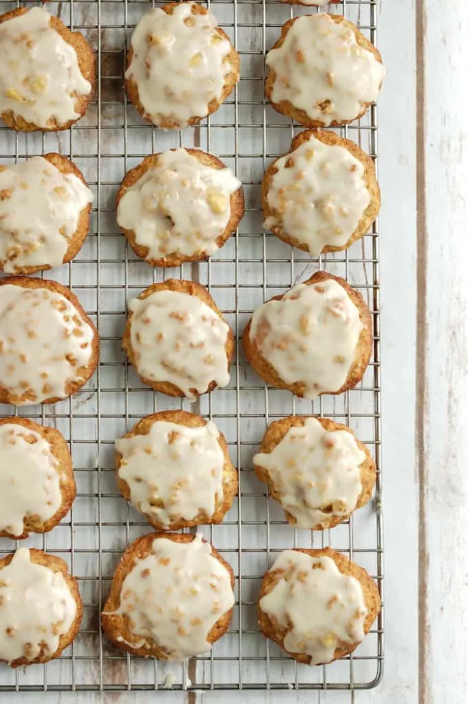 rows of iced apple oatmeal cookies on a cooling rack