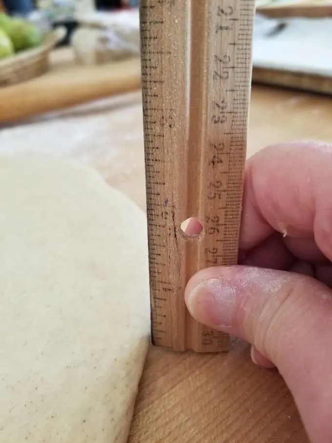 a ruler measuring donut dough at 1/4" thick