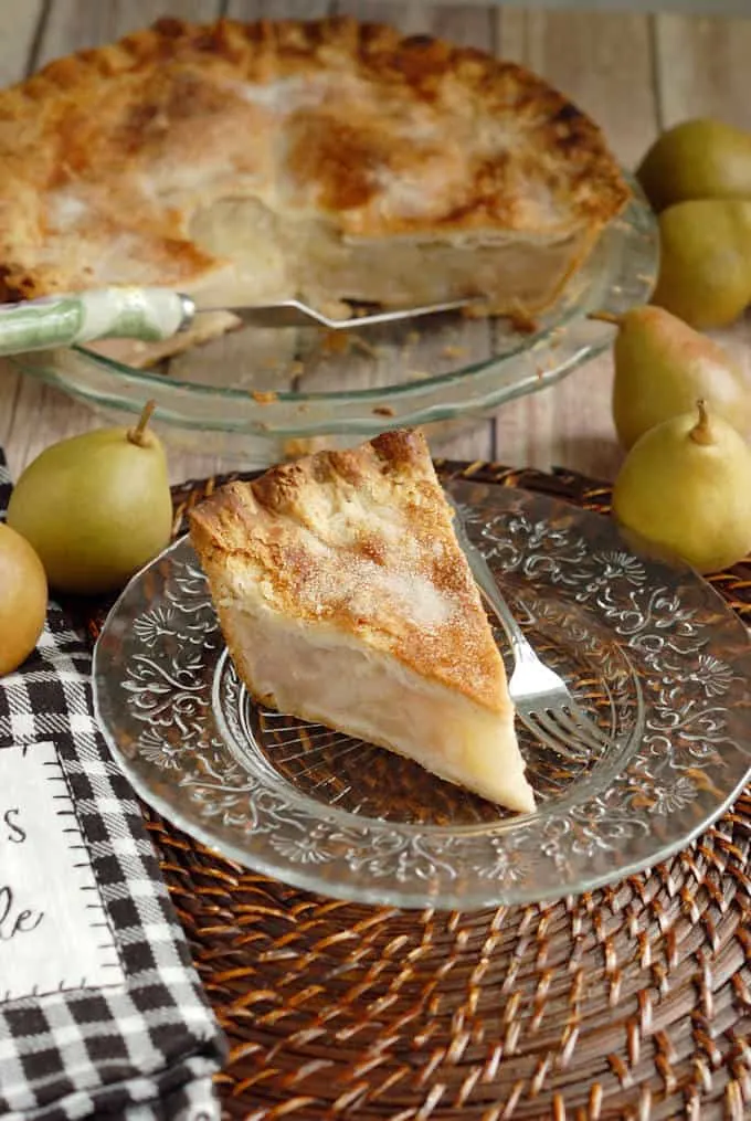 a slice of vanilla pear pie on a glass plate