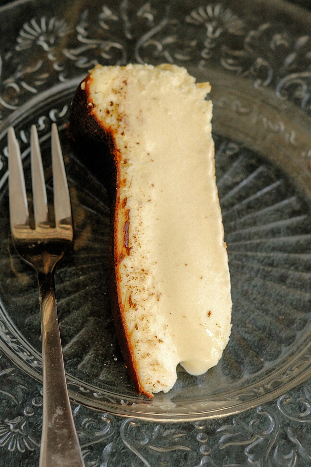 a slice of basque burnt cheesecake on a glass plate.