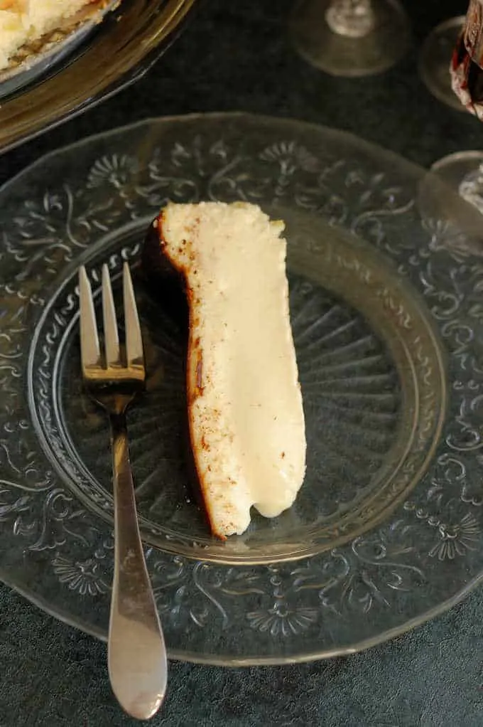 a slice of san sebastian cheesecake on a glass plate.