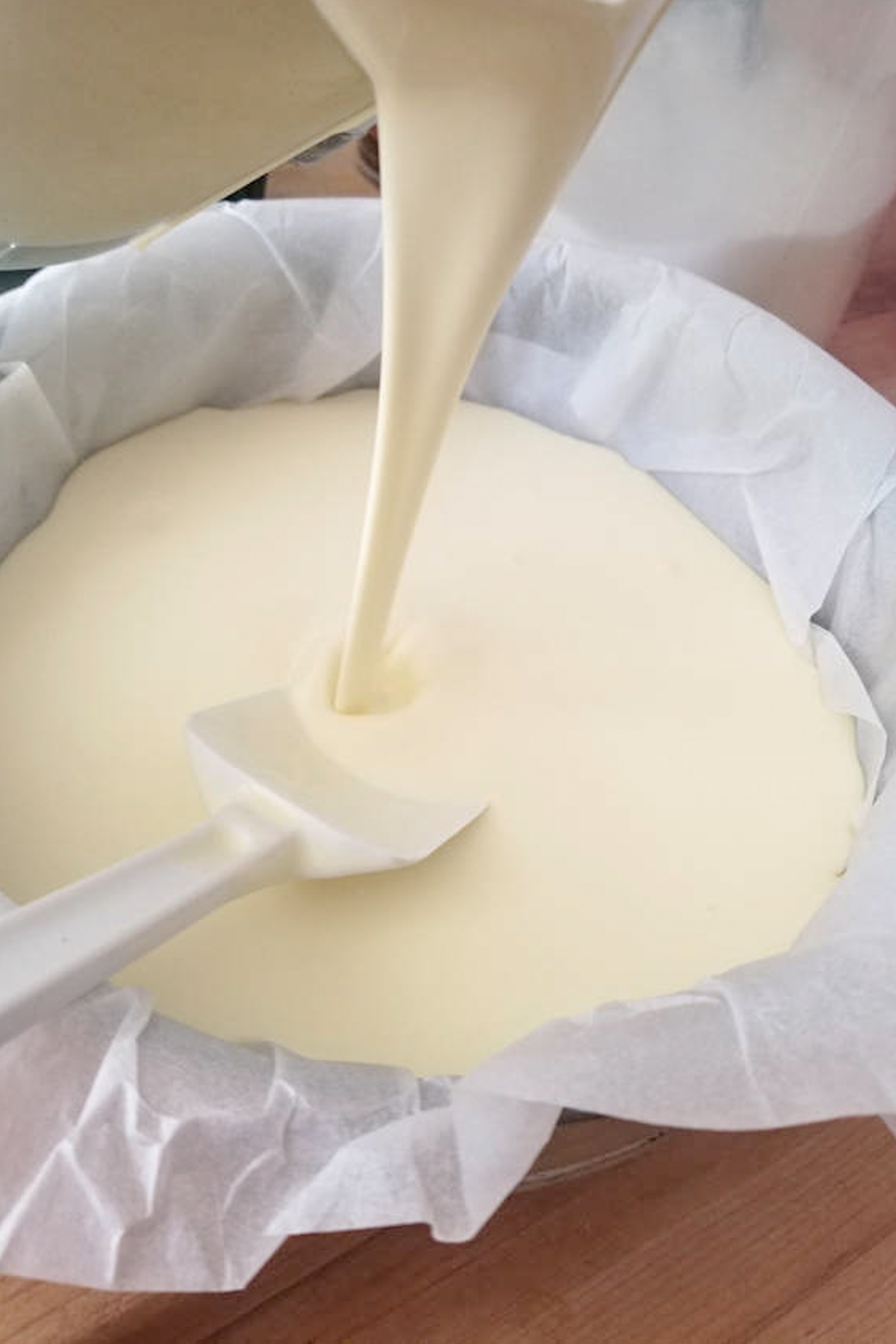 cheesecake batter poured into a parchment lined pan.