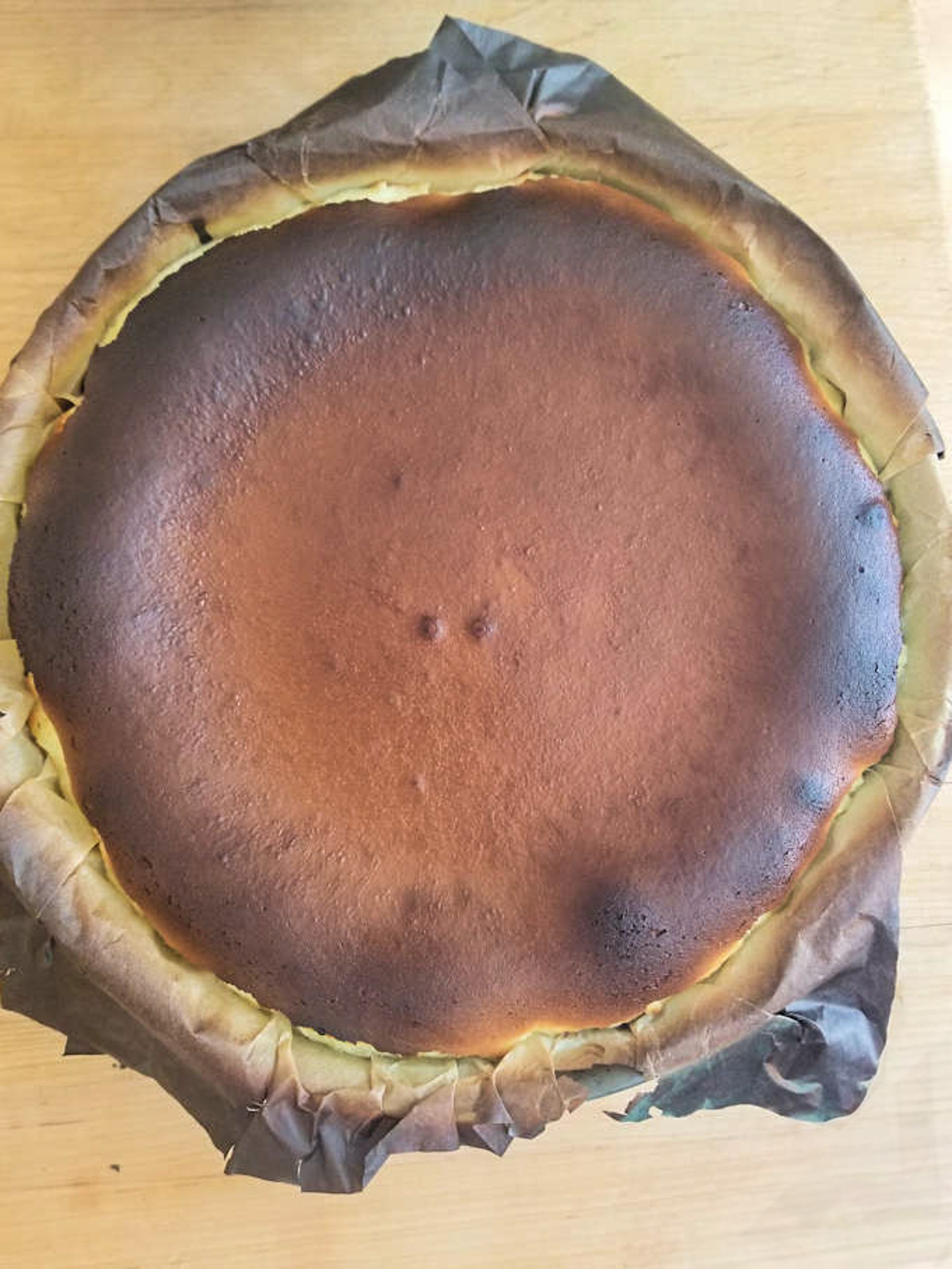 a burnt basque cheesecake on a wood table.