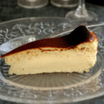 a slice of basque burnt cheesecake on a glass plate.