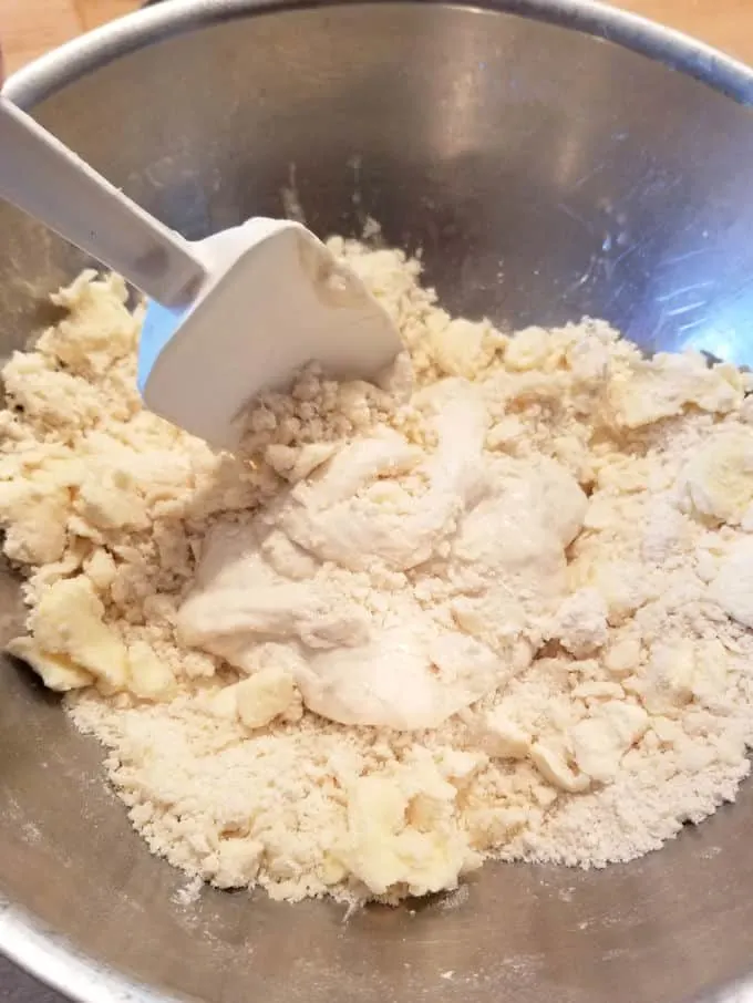 a spatula mixing a bowl of sourdough pie dough