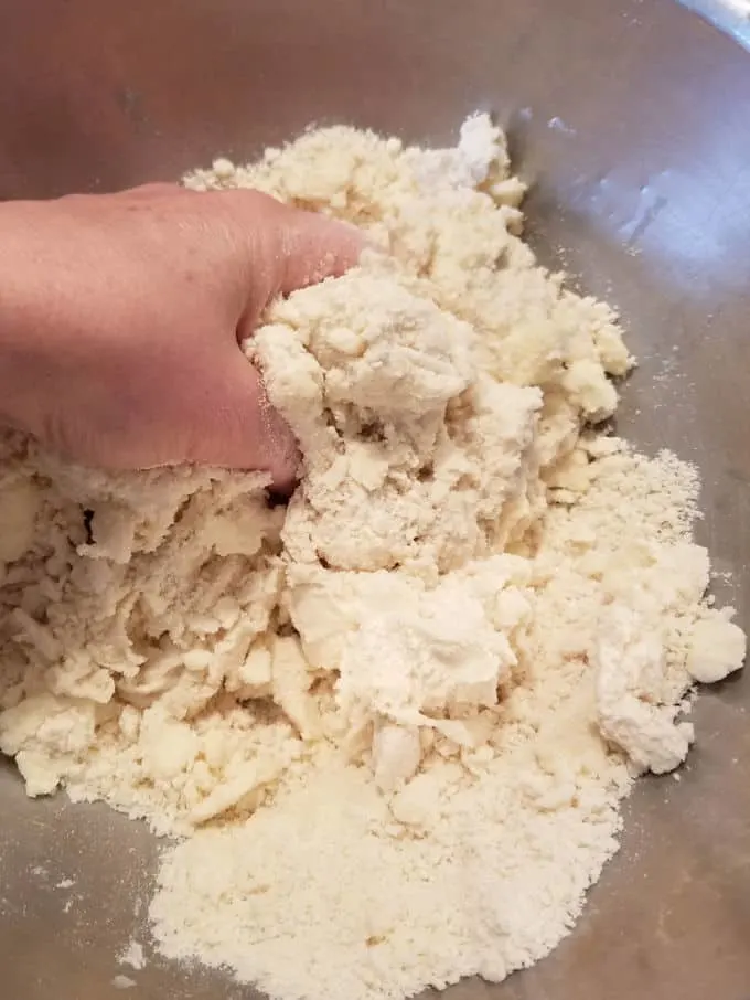 a hand mixing sourdough pie dough