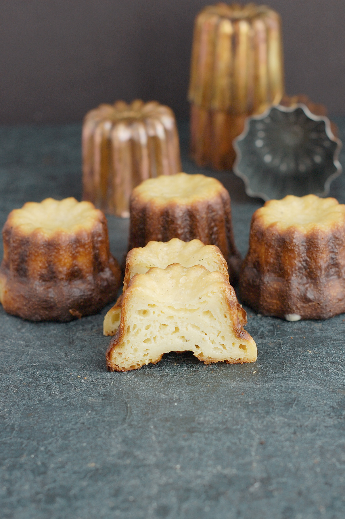 a split canele on a black surface.