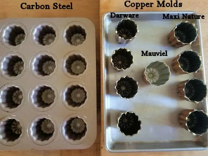 an assortment of canele pans on a table, set up for testing