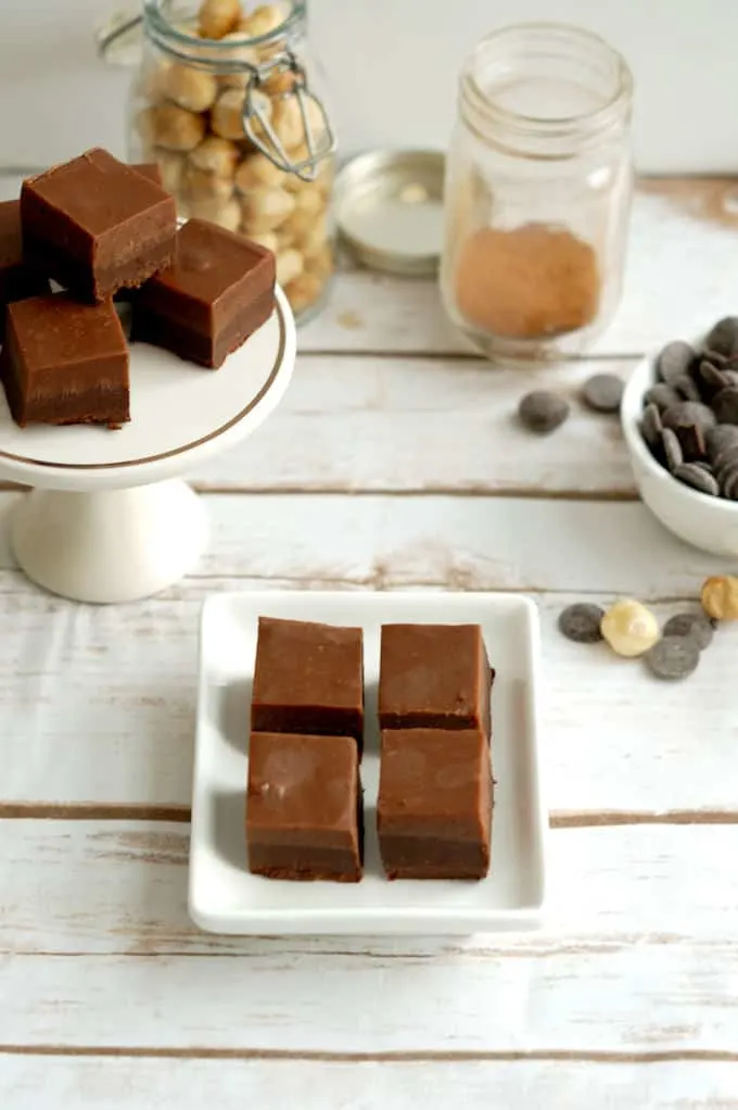 a table with trays of layered hazelnut truffles, a jar of cinnamon and some hazlenuts