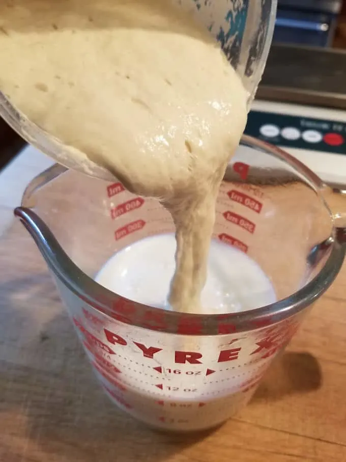 pouring sourdough starter into buttermilk to make sourdough scones