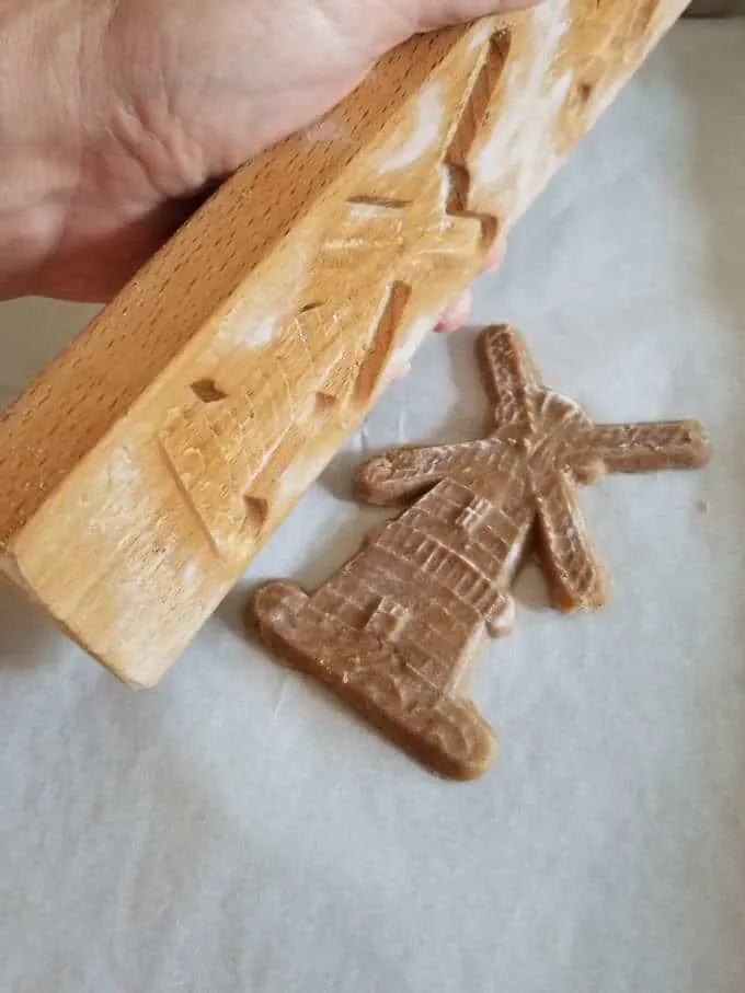 a speculaas cookie flipped out of the mold onto a cookie tray