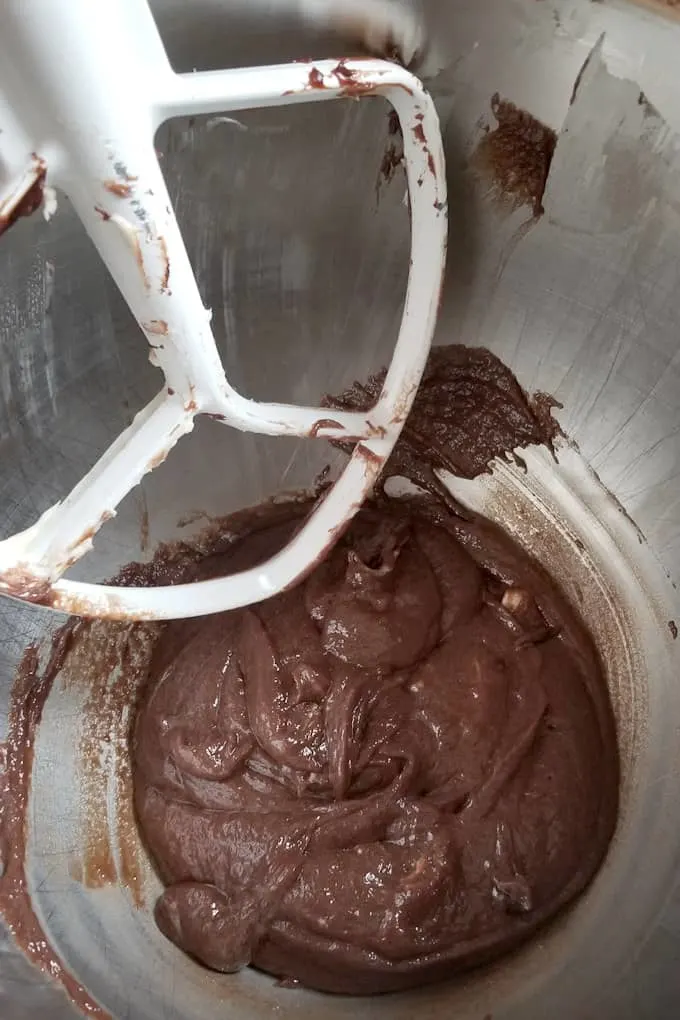 malted chocolate frosting in a mixing bowl before it is whipped