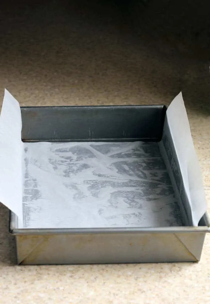 a photo showing how to line a 13x9 baking pan with parchment paper to bake brownies