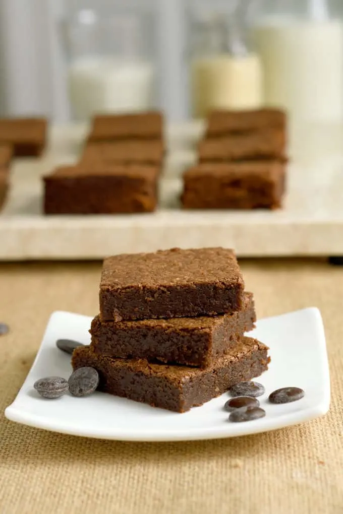 a stack of un-iced malted milk brownies on a plate