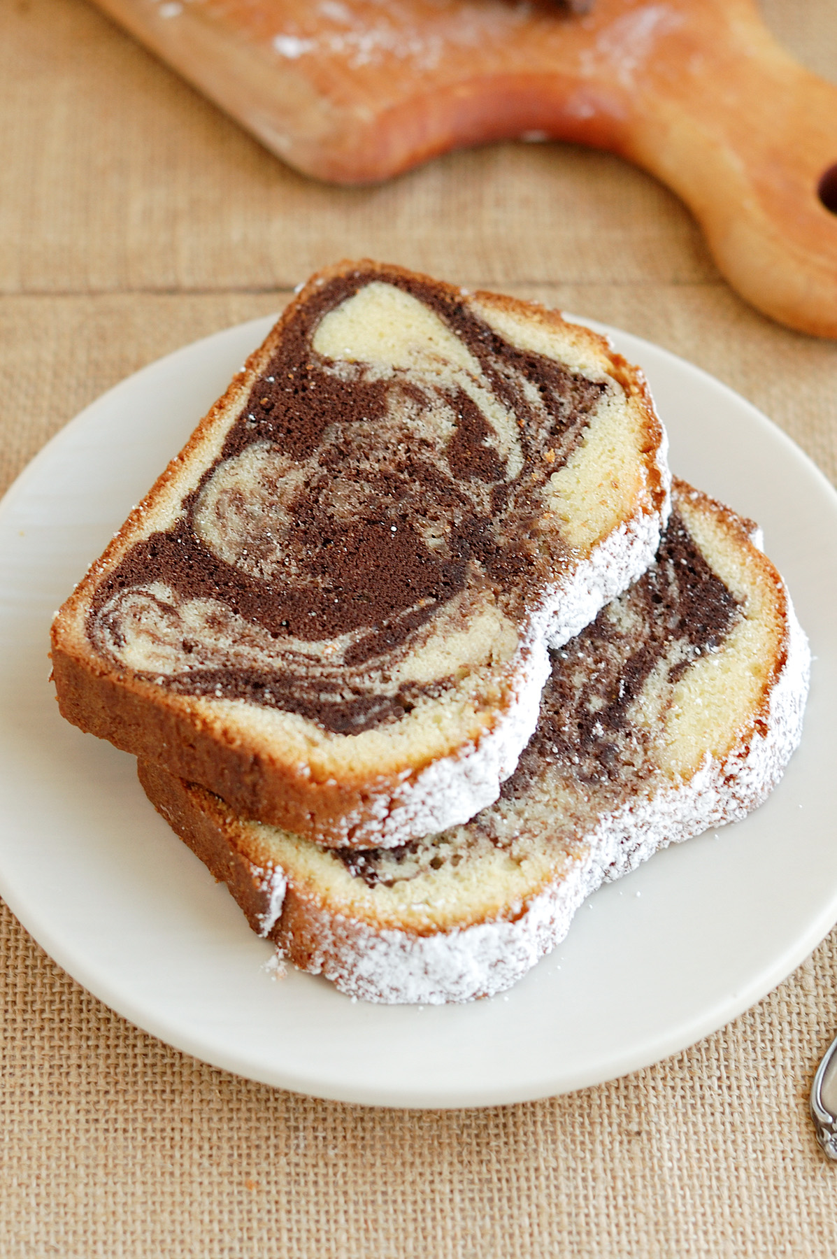 two slices of marble pound cake on a white plate.