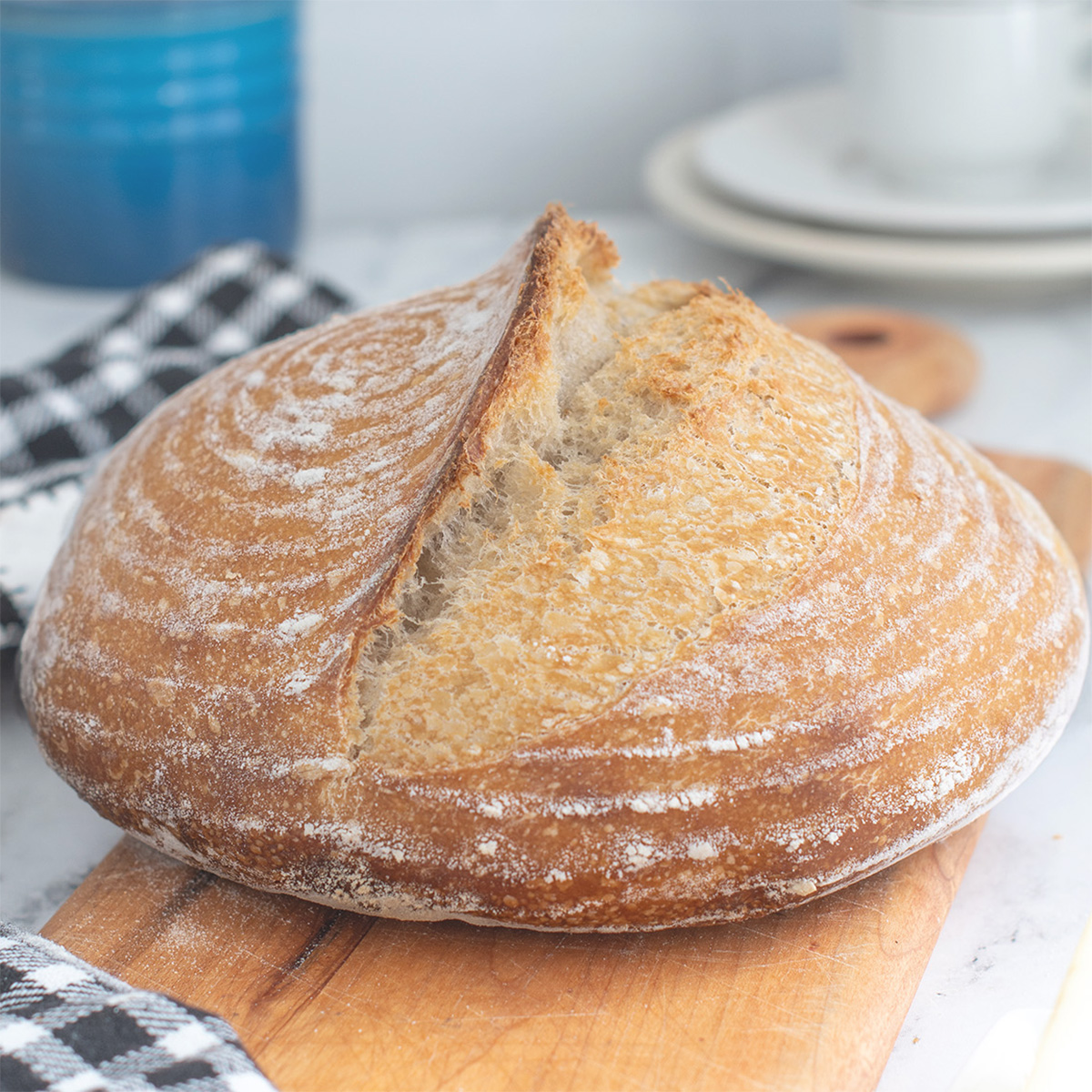 a loaf of sourdough bread on a cutting board.
