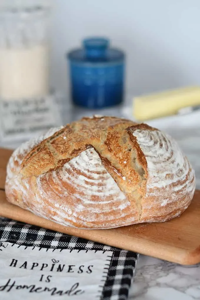 a loaf of artisan sourdough bread on a cutting  board