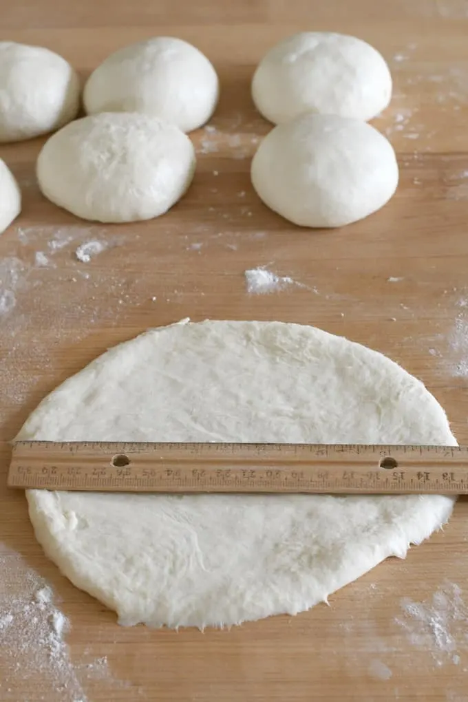 a ruler measuring a round of dough