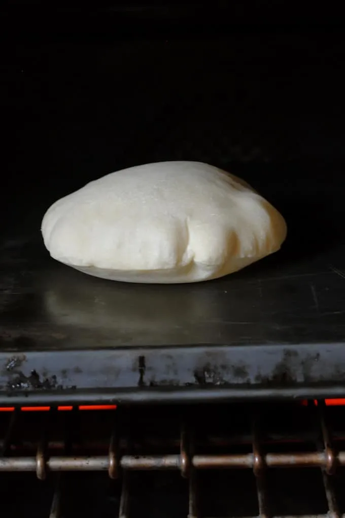 a sourdough pita bread puffing in the oven