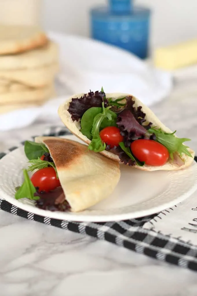 a plate with a sourdough pita bread filled with salad