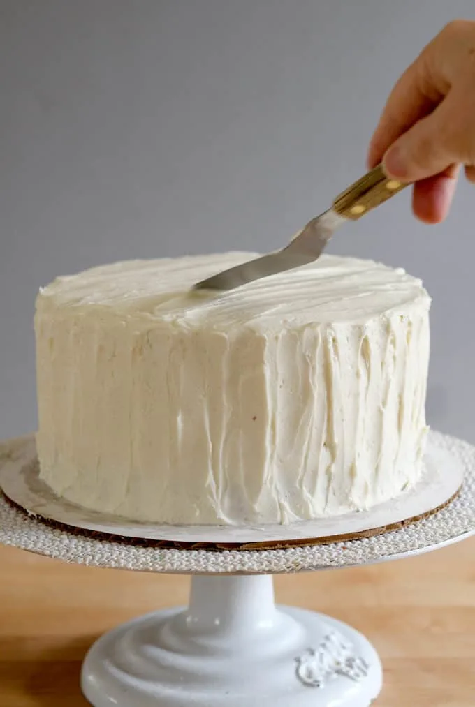 a small spatula icing a cake with ermine frosting