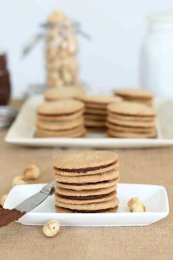 a stack of nutella sandwich cookies on a white plate