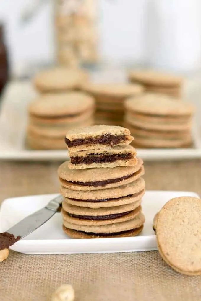 a stack of nutella sandwich cookies with one broken in half to show the filling