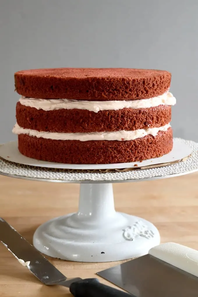 an uniced red velvet cake on a cake turntable