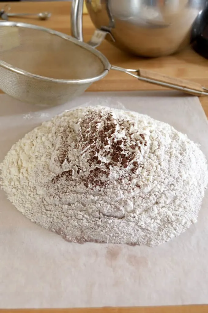 flour and cocoa sifted on to a sheet of parchment paper