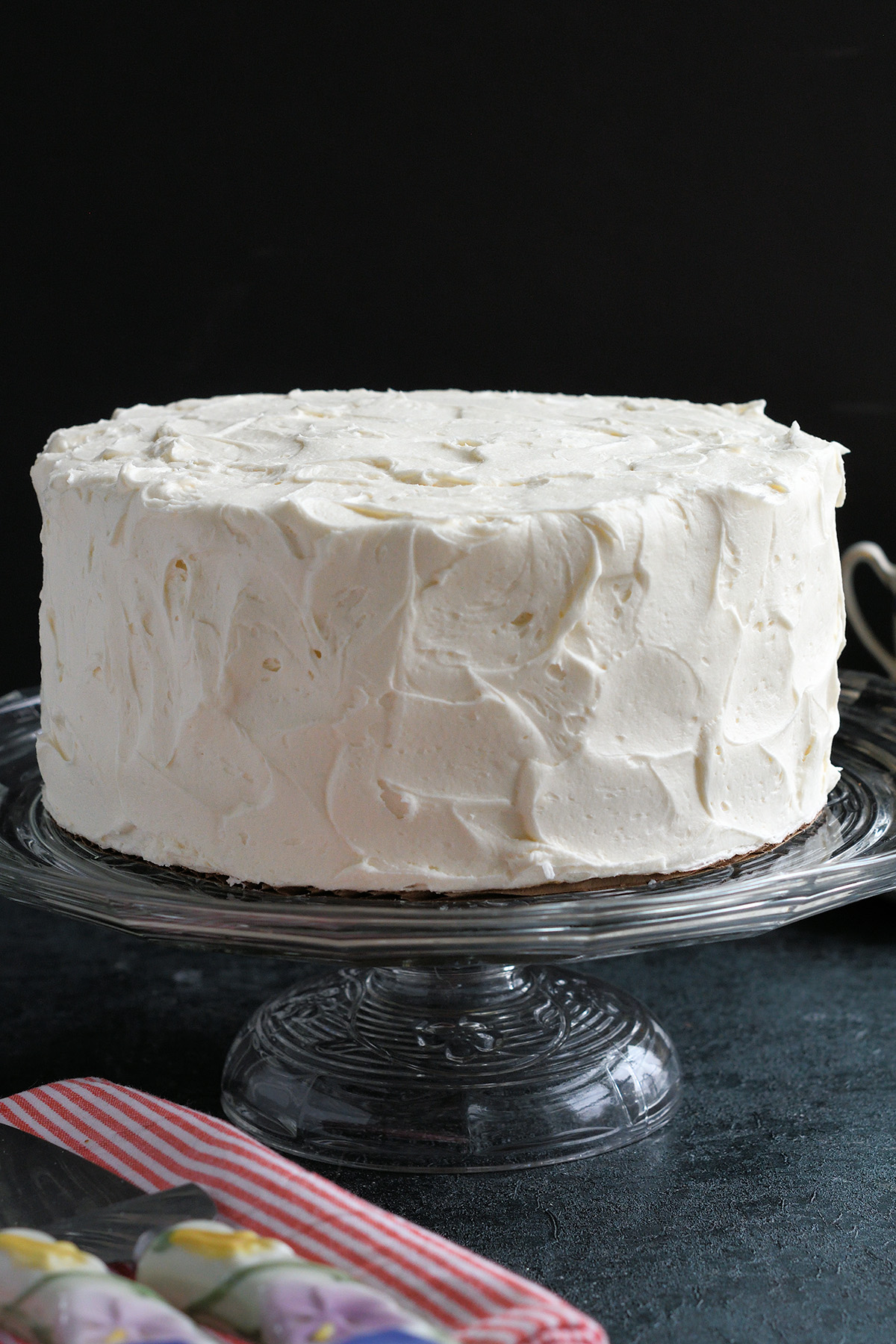 a vanilla cake on a cake stand.